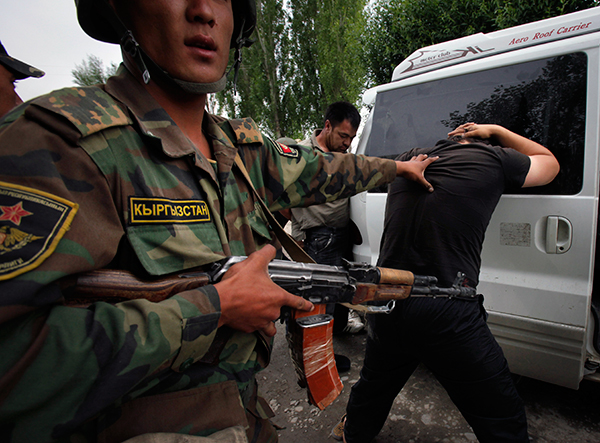 Киргизские солдаты обыскивают задержанного на границе гражданина Узбекистана. Фото: Александр Земляниченко / AP